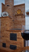 Кирпичная печь с полками и бокалом вина на столе