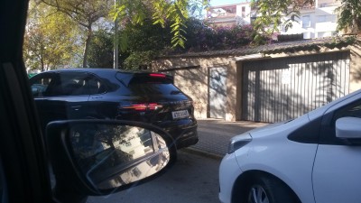 Чёрный кроссовер припаркован рядом с белым автомобилем в Испании