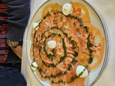 Тарелка с нарезанными помидорами и соусом