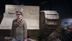 Человек в военной форме рядом с танком в музее
